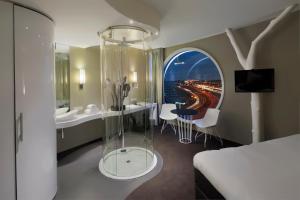 阿姆斯特丹阿姆斯特丹弗莱彻酒店的酒店客房带一张床和一个玻璃淋浴间