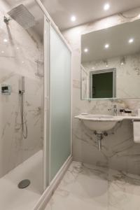 佛罗伦萨阿普丽雷帕拉索达博尔戈酒店的白色的浴室设有水槽和淋浴。