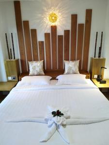 高当Mingalar Boutique Hotel的两张带白色床单和花卉的床