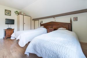 霍恩Bed and Breakfast Hoorn的卧室设有两张床、白色床单和电视。