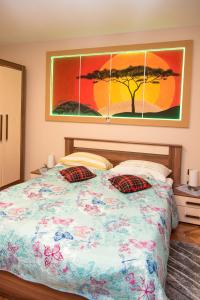 达鲁瓦尔Rooms Vlado的卧室配有一张床,墙上挂有绘画作品