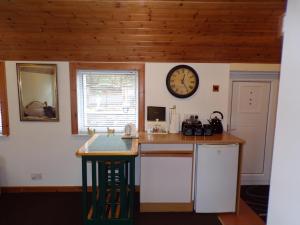 莫法特Groom's Cottage的厨房配有柜台和墙上的时钟