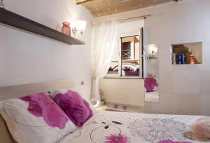 罗马Domus Paradiso City Center的一间卧室配有一张带紫色枕头和镜子的床