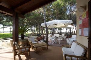 法维尼亚纳Residence Punta Longa的庭院配有桌椅和遮阳伞。