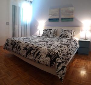 布雷拉Apartment MIVA的一间卧室配有一张带两盏灯的黑白床。