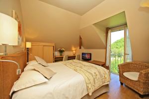 罗卡马杜尔Hotel Beau Site - Rocamadour的一间卧室设有一张大床和一个窗户。