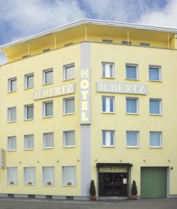 科隆依贝茨嘉利酒店的一座黄色的建筑,上面标有阅读莱比锡酒店标志