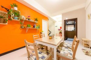 台南拍R平方电梯民宿的一间拥有橙色墙壁和桌椅的用餐室