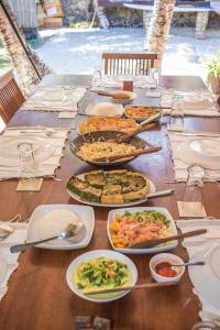 内布拉拉Malole Surf House的一张长桌,上面放着许多盘子的食物