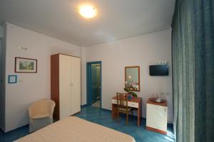 马奥莱奥西酒店的酒店客房配有一张床铺、一张桌子和一张书桌。