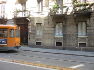 都灵Il Sogno Torino Guesthouse的停在大楼前的橙色巴士