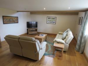 切普斯托Welsh Apple Barn的客厅配有两张沙发和一台电视机