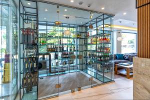 雅典Glyfada Riviera Hotel的一间装满许多葡萄酒瓶的玻璃墙客房