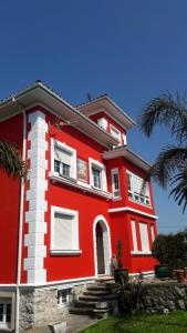 桑坦德La Torre del Indiano的棕榈树下的红色和白色房子