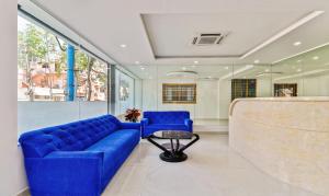 班加罗尔Treebo Trend Blu Orchid的客厅配有蓝色的沙发和桌子