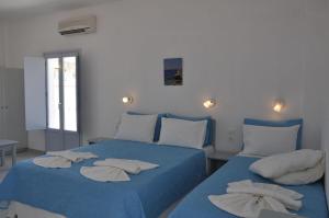 阿吉亚利Studios Akrogiali的配有两张床铺的蓝色床单和枕头