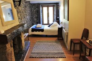 Montpezat-sous-Bauzon蒙佩扎宾馆的带壁炉的客房内的一间卧室配有一张床