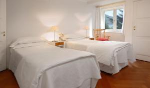 圣卡洛斯-德巴里洛切屯克林酒店的白色客房的两张床,设有窗户