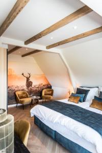 Vogelenzangde Vogelensangh的一间卧室配有两张床,还有一幅鹿画