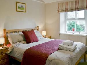 HawesMiddlegate Cottage的一间卧室设有一张大床和一个窗户。