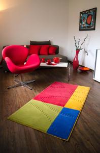 塔勒Ferienwohnung Christine的客厅配有红色的沙发和色彩缤纷的地毯