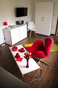 塔勒Ferienwohnung Christine的客厅配有桌子和红色椅子