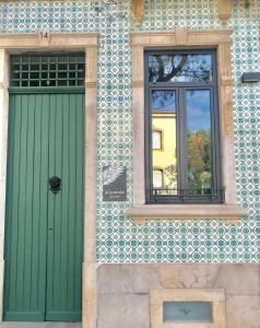法鲁HOSTEL ALAMEDA EXCLUSIVE HOUSE的大楼的绿色门和窗户