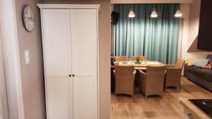 特兹萨茨Apartament Comfort的一间带桌椅和时钟的用餐室