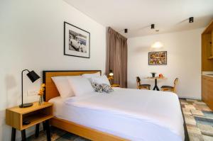 耶路撒冷Biazi Hotel的卧室配有一张白色的大床和一张桌子