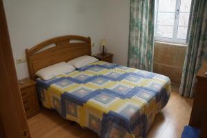穆罗斯apartamento do curro的一间卧室配有一张带蓝色和黄色被子的床