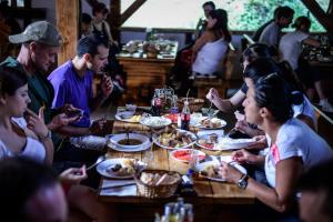 HumCamp Divlja Rijeka的一群坐在桌子旁吃食物的人