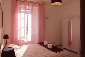 罗马Appartament Piramide Cestia的一间卧室配有床和一个带粉红色窗帘的窗户。