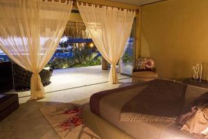 Santa María ColotepecSamora Luxury Resort的一间卧室设有一张床和一个大窗户