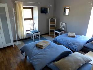 巴利纳莫尔Garadice View Farm House的配有两张床铺的房间,配有两把椅子和电视
