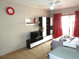 阿德耶Mareverde, Costa Adeje, pool view terrace的客厅配有电视、沙发和时钟