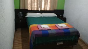 新帕尔米拉Casa La Norma的一间卧室配有一张色彩缤纷的床和毛巾