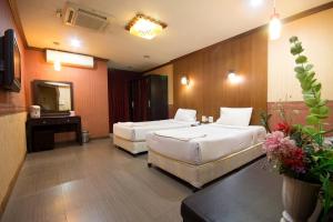坤敬Khon Kaen Ruenrom Hotel的酒店客房,设有两张床和镜子