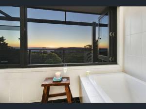 肯图巴Narrow Neck Views - Peaceful 4 Bedroom Home with Stunning Views!的带浴缸的浴室以及带蜡烛的桌子。