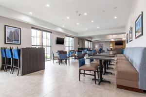 亨博尔Comfort Suites Humble Houston IAH的餐厅内带桌椅的用餐室