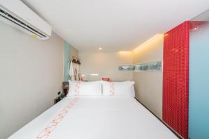 曼谷Vib Best Western Sanam Pao的卧室配有白色的床和红色床头板