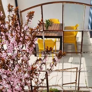 马格德堡ElbQuartier Apartments Magdeburg 'Die Stadtoase'的阳台配有一张桌子和椅子,并种植了粉红色的鲜花