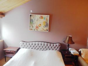 第比利斯第比利斯时光旅馆的卧室配有一张床,墙上挂着一幅画