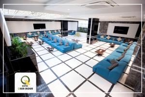纳杰夫Qasr AlDur Hotel的大堂设有蓝色的沙发和电视