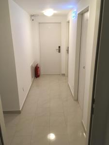 维也纳CH-Hostel的一条带白色门和红色手提箱的走廊