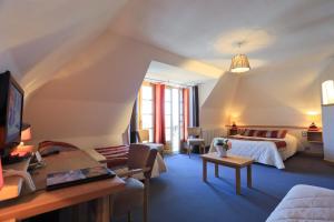 萨莱Logis Hôtel Restaurant & Spa les Remparts的一间卧室设有一张床和一间客厅。