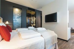 柏林Riu Plaza Berlin的卧室配有一张白色大床和一台平面电视。