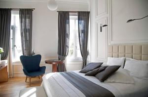 雅典Four Streets Athens - Luxury Suites Apartments in Athens的一间卧室配有一张带蓝色椅子的床和窗户