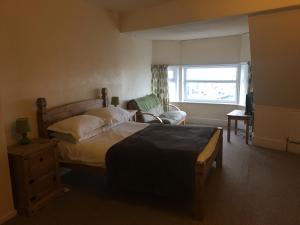 布莱克浦Camelot Seafront Hotel的卧室配有床、椅子和窗户。