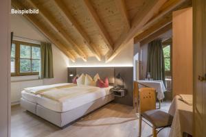 斯图姆La Pasta Hotel Restaurant的一间卧室设有一张带木制天花板的大床