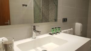 托洛萨奥里亚酒店的浴室设有白色水槽和镜子